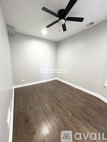 A room with a ceiling fan and wooden flooring.