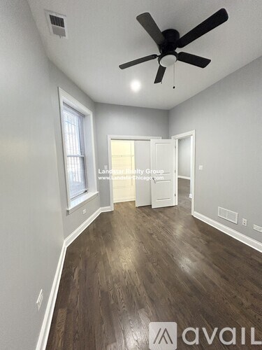 A room with a ceiling fan and wooden flooring.