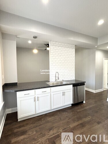 A kitchen with white cabinets and a black countertop.