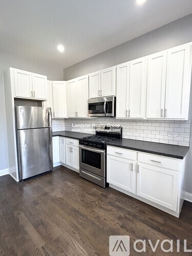 A kitchen with white cabinets and a stainless steel refrigerator.