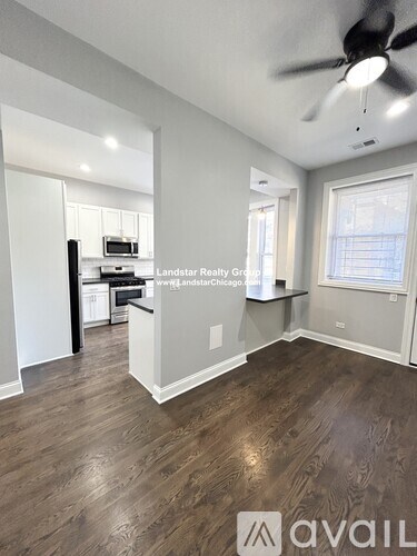 A room with a ceiling fan and wooden flooring.