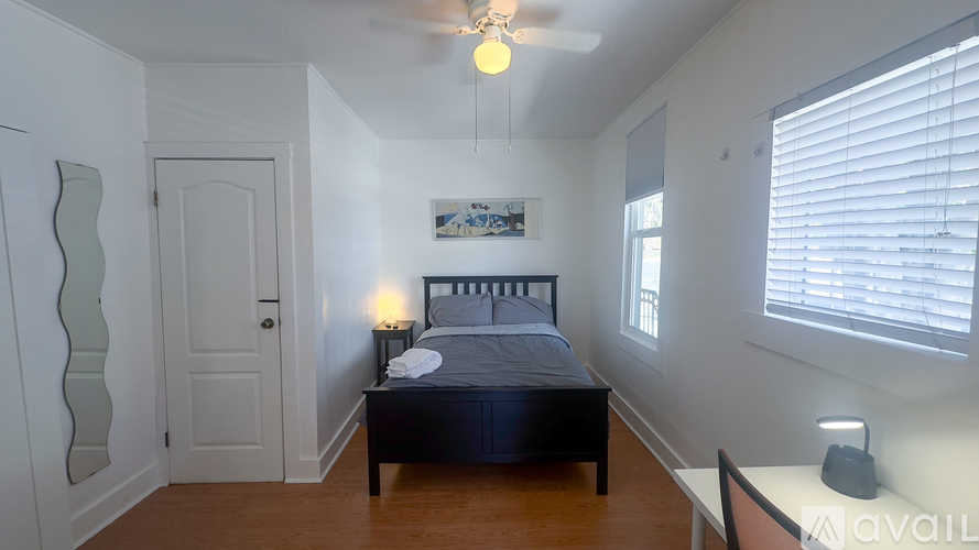 A bedroom with a bed, nightstand, and a ceiling fan.