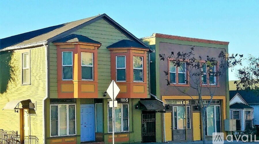 A row of colorful houses with a street sign in front.