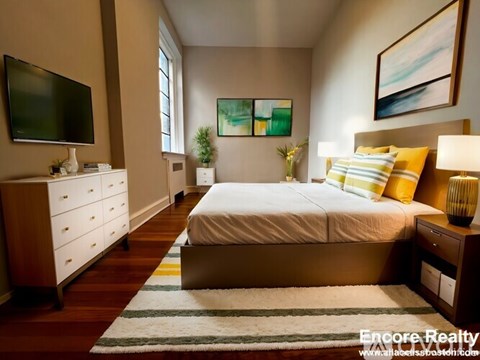 A bedroom with a bed, nightstand, and a television.
