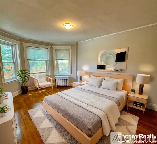 A bedroom with a large bed and a mirror on the wall.