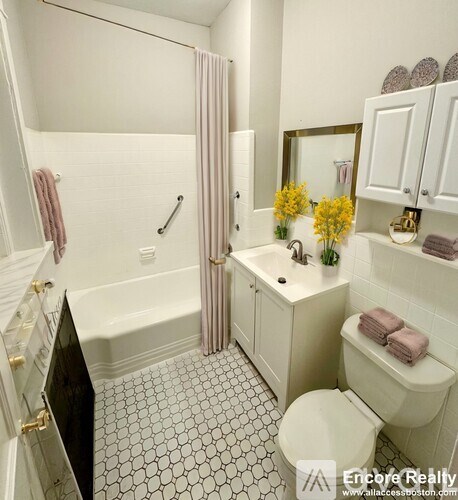 A white bathroom with a black and white floor.
