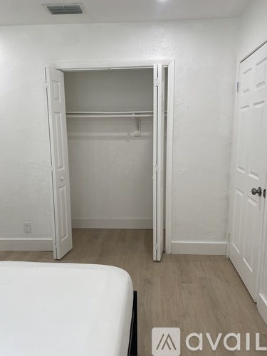 A bedroom with a bed, wardrobe and open closet door.