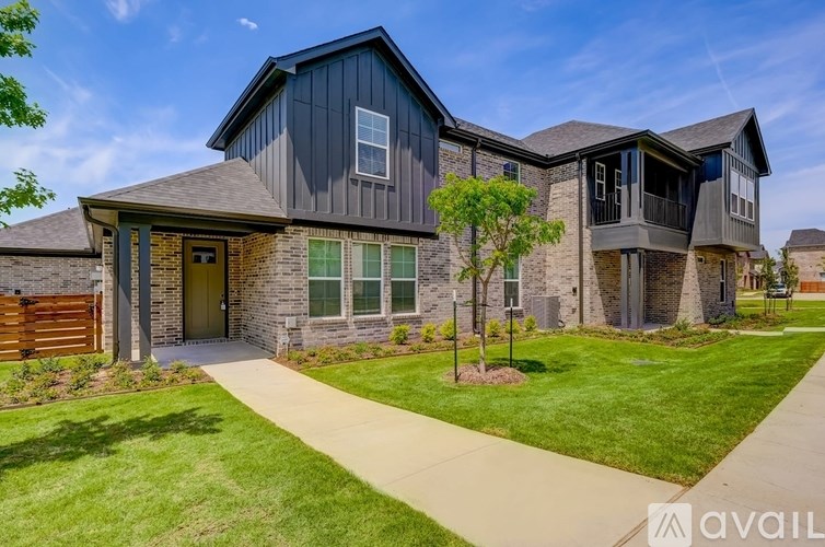 A modern house with a grey exterior and a wooden fence.