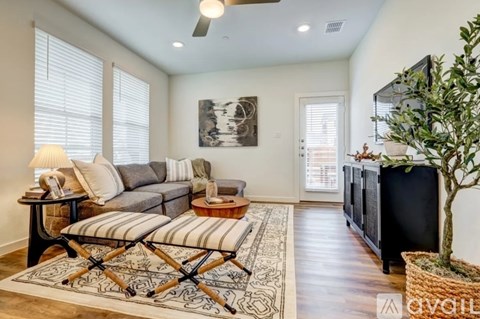A living room with a grey couch and a black and white striped chair.