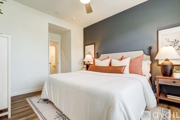 A bedroom with a large bed and a ceiling fan.