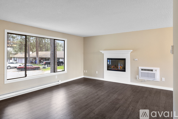 A spacious living room with a fireplace and large windows.