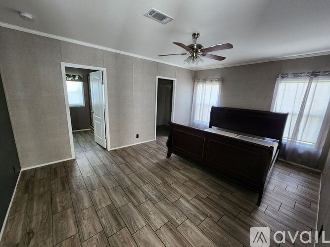 A room with a ceiling fan and a bed.