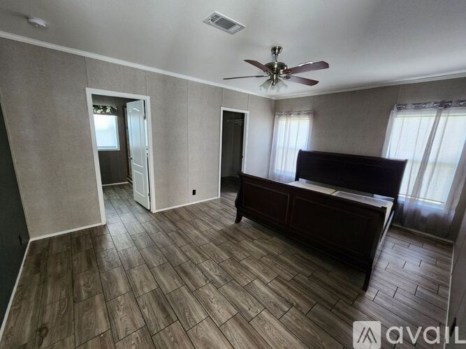 A room with a ceiling fan and a bed.