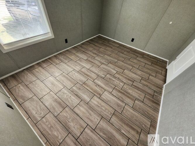 A room with a wooden floor and a window.