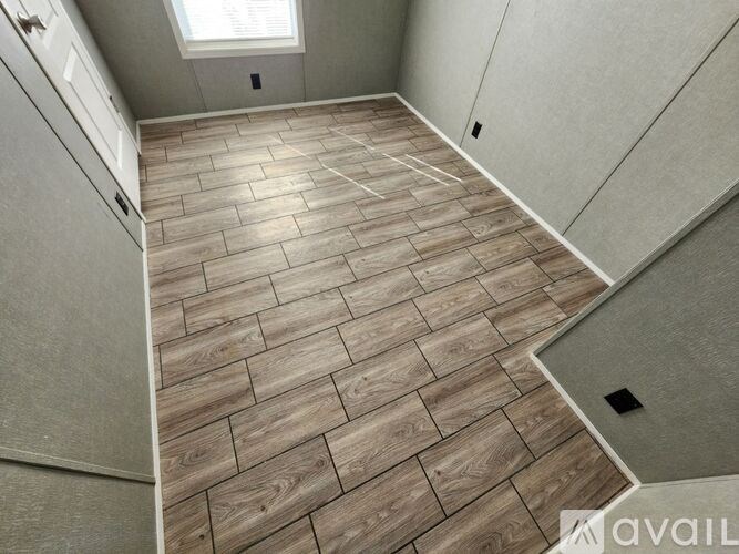 A wooden floor in a room with a skylight.