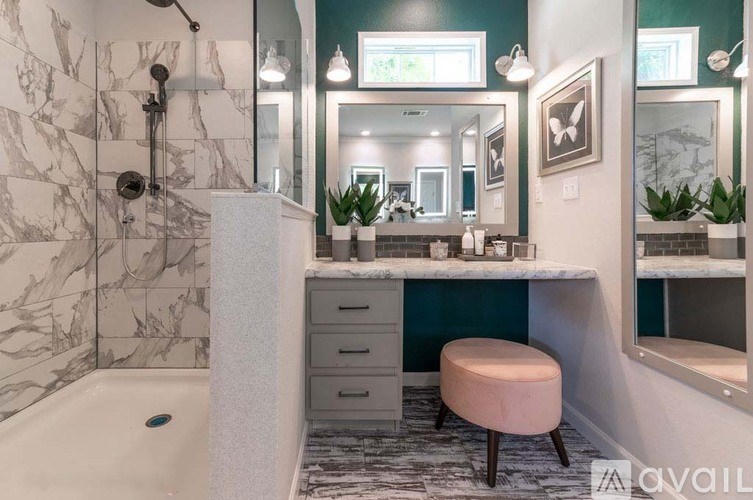 A bathroom with a marble tiled shower and a white bathtub.