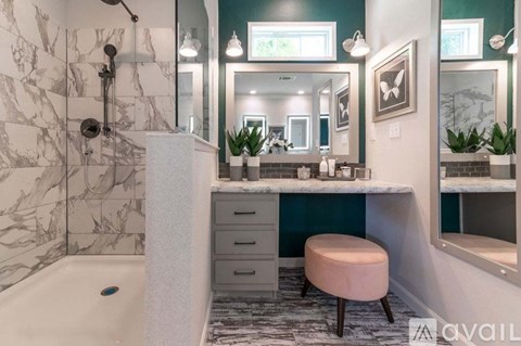 A bathroom with a marble tiled shower and a white bathtub.