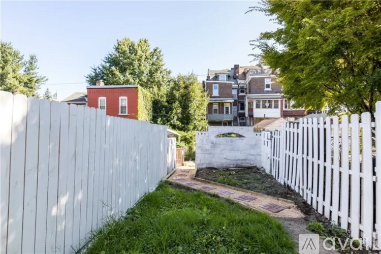 A white picket fence runs along the side of a grassy area.