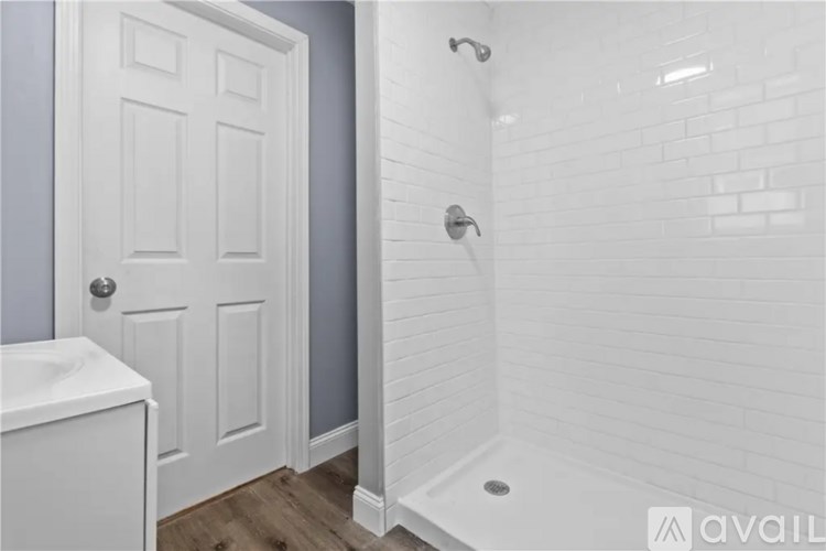 A white door is next to a white sink in a bathroom.