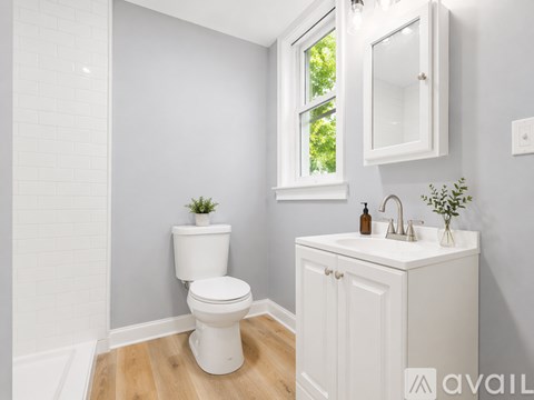 A white toilet and sink in a bathroom.