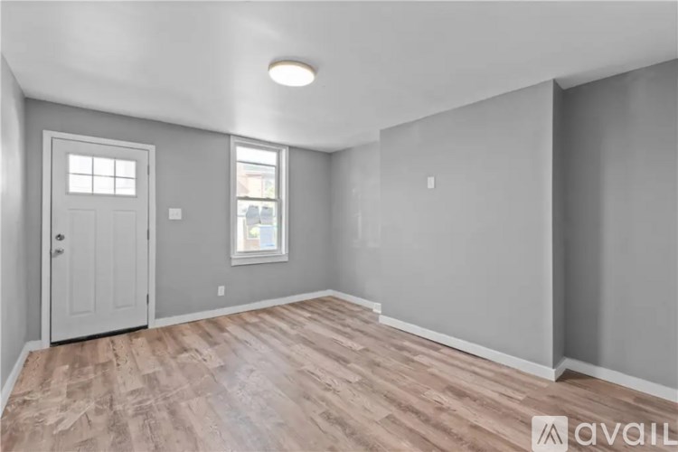 A room with a wooden floor and a window.