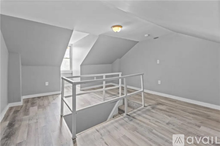 A room with a white ceiling and a wooden floor with a metal frame in the middle.