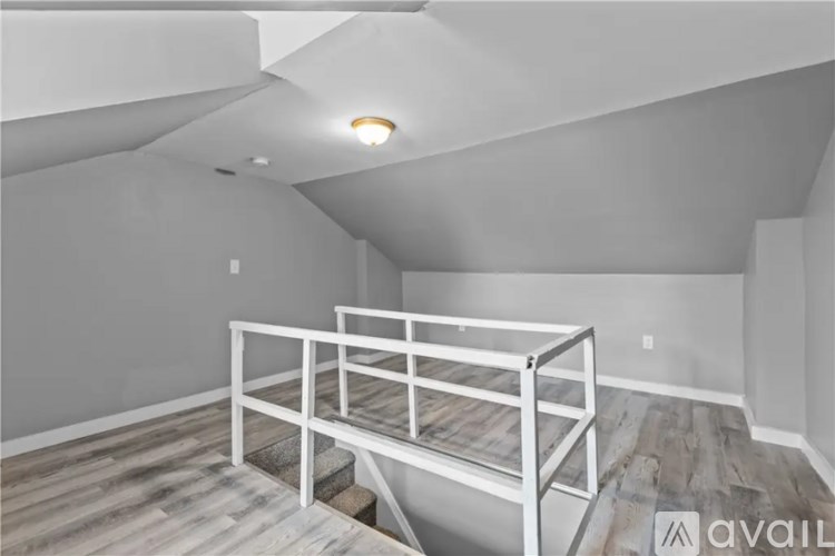 A white metal bunk bed in a room with wooden flooring.