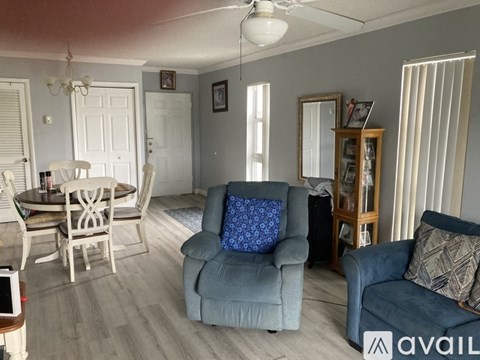 A living room with a blue couch and a dining table.