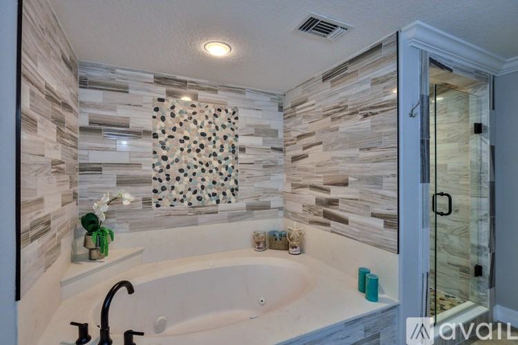 A bathroom with a stone wall and a bathtub.