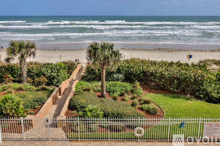 A beach scene with a pathway leading to the ocean.