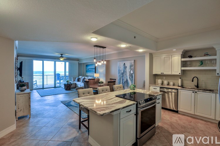 A kitchen with a large island and a dining table with chairs.