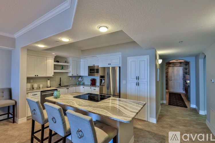A kitchen with a marble countertop and a breakfast bar.