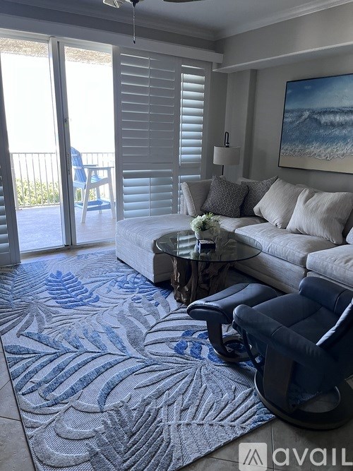 A living room with a couch, chairs, and a rug.