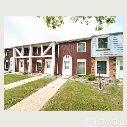 A row of houses with a grassy front yard.