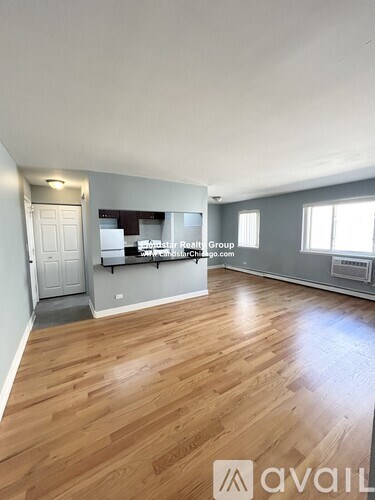 A spacious room with wooden flooring and a white door.