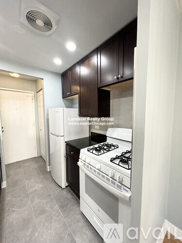 A kitchen with a stove top oven and a refrigerator.