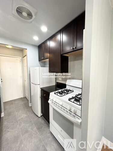 A kitchen with a stove top oven and a refrigerator.