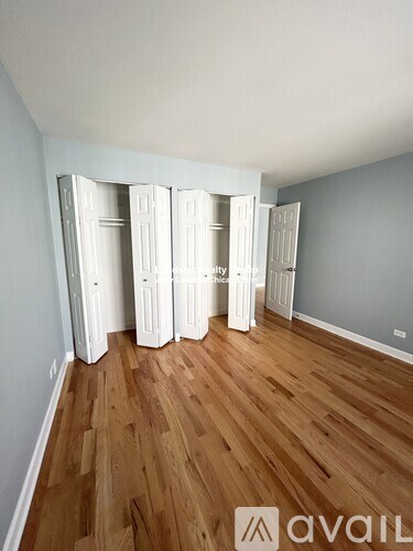 A room with wooden floors and white wardrobes.