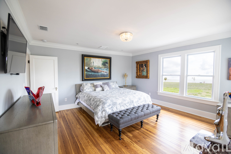 A bedroom with a large bed and a painting on the wall.