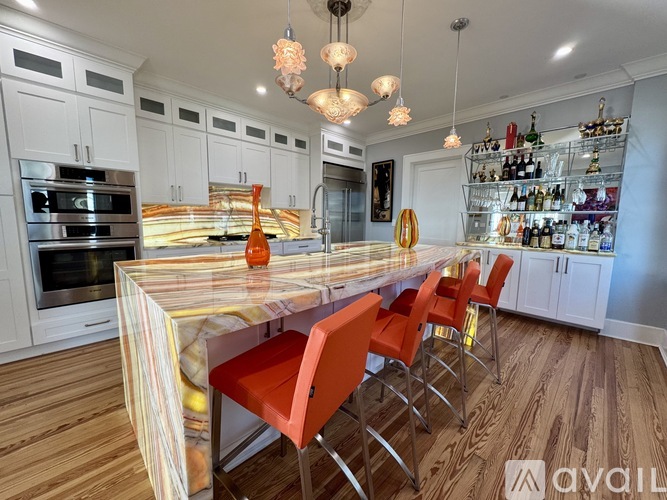 A kitchen with a long table and chairs.