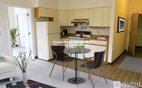A kitchen area with a table and chairs in the foreground.