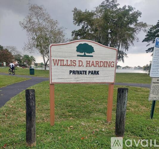 A park with a paved path and trees.