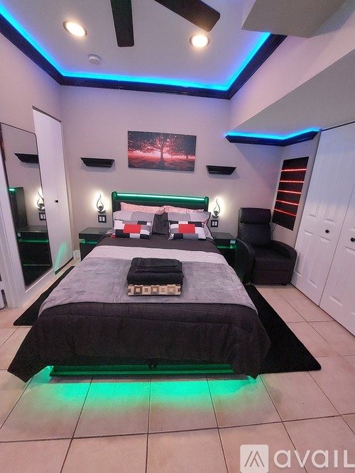 A bedroom with a bed, a mirror, and a painting on the wall.