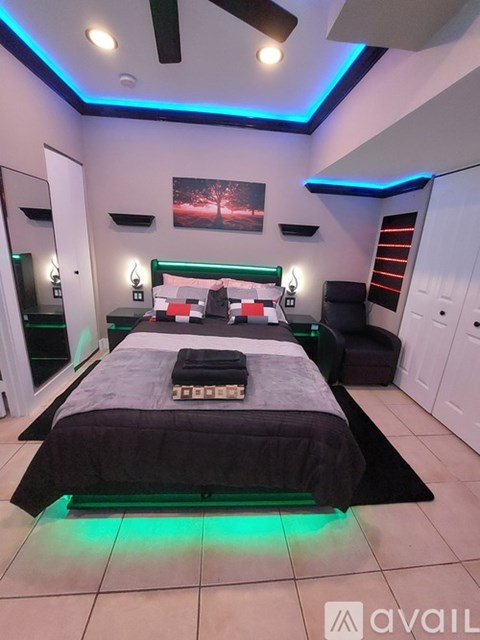 A bedroom with a bed, a mirror, and a painting on the wall.