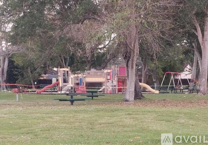 A playground with a red slide and a green picnic table.