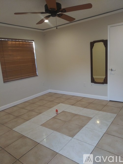 A room with a ceiling fan and a tiled floor.