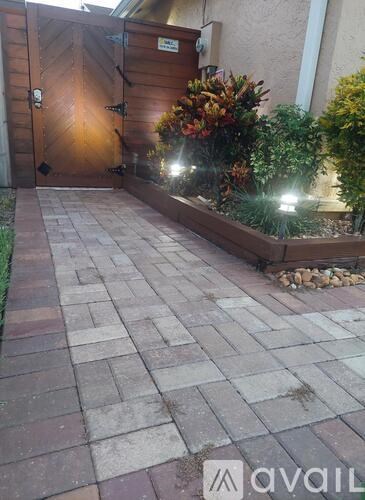 A wooden gate with a metal handle and a sign above it.