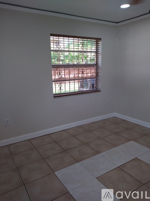 A room with a window and tiled floor.