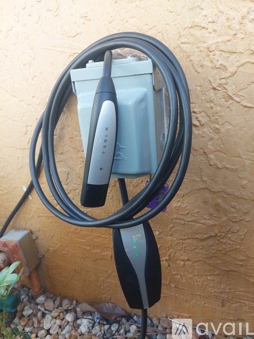 A grey power strip with two cords plugged into it.