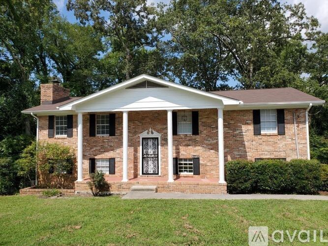 A brick house with a white porch and a white door.